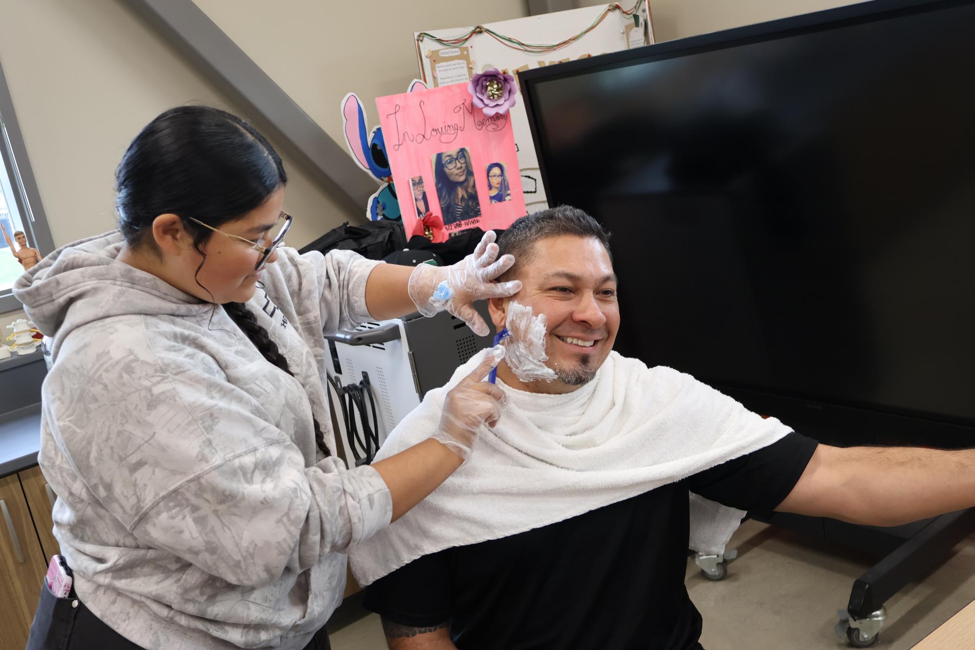 Mr. Celaya is shaved by a CNA student, Leslie Soto.