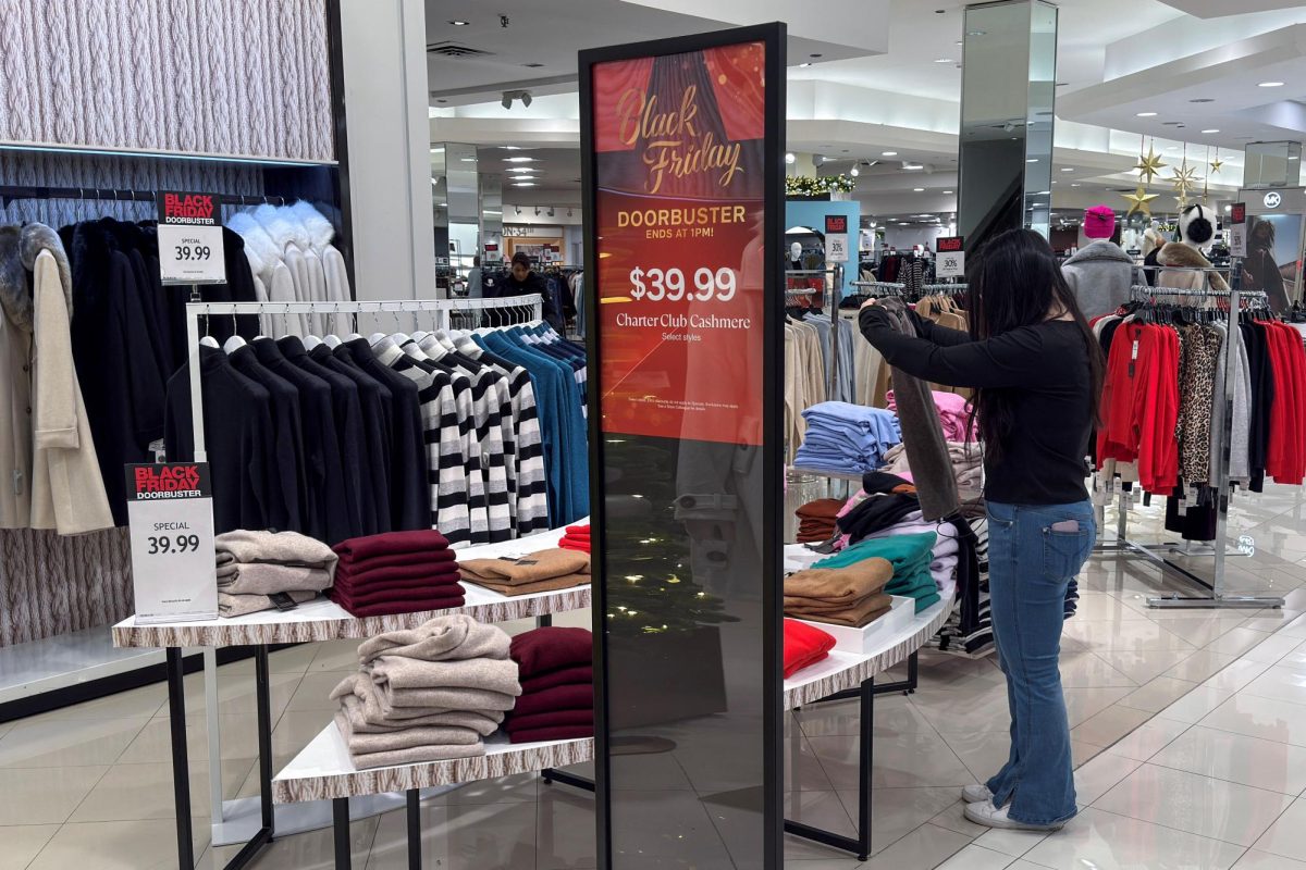 An employee folds clothes at a Macy's department store during Black Friday deals, a post Thanksgiving shopping frenzy that attracts throngs of bargain hunters to stores, at the Roosevelt Field mall in Garden City, New York, U.S., November 28, 2025. REUTERS/Shannon Stapleton