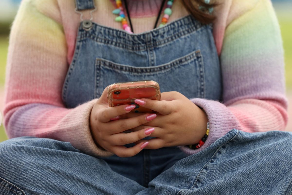 A girl uses her mobile phone in Sydney, Australia, November 22, 2025. REUTERS/Hollie Adams