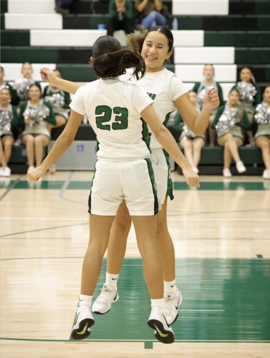 Samantha Gonzalez (23) and Kaylee Rodriguez (11) completing their personal handshake at the start of the game.